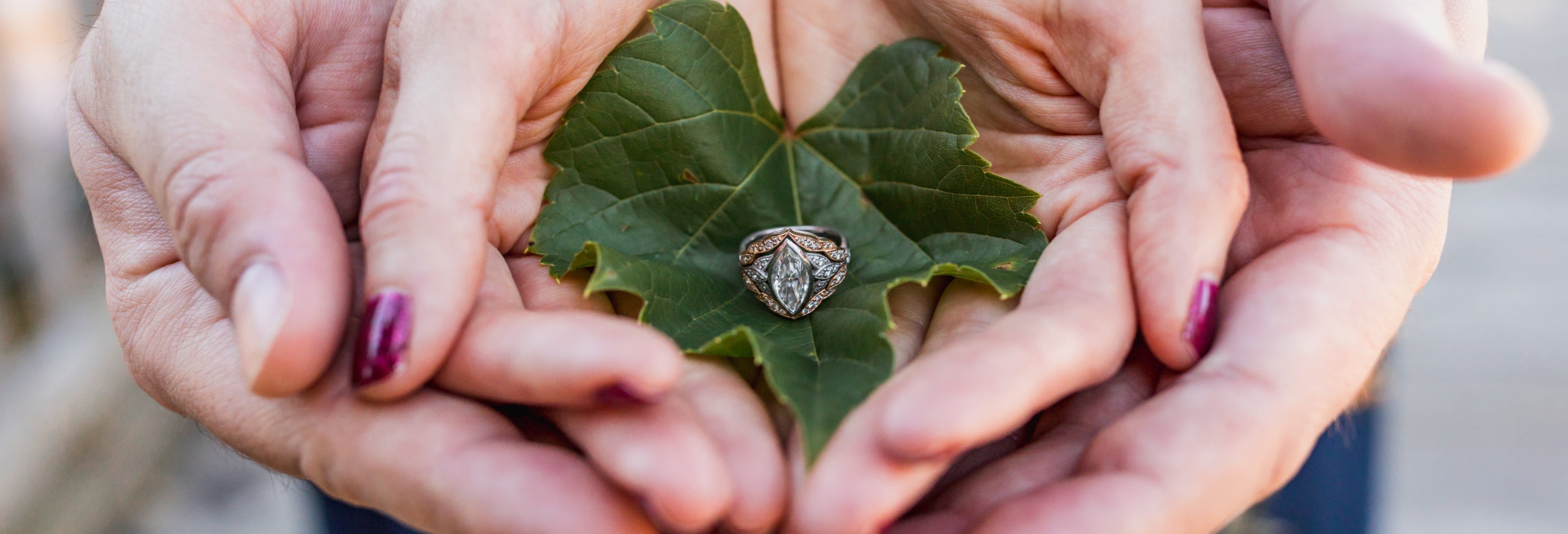 a custom engagement ring being held by two sets of hands